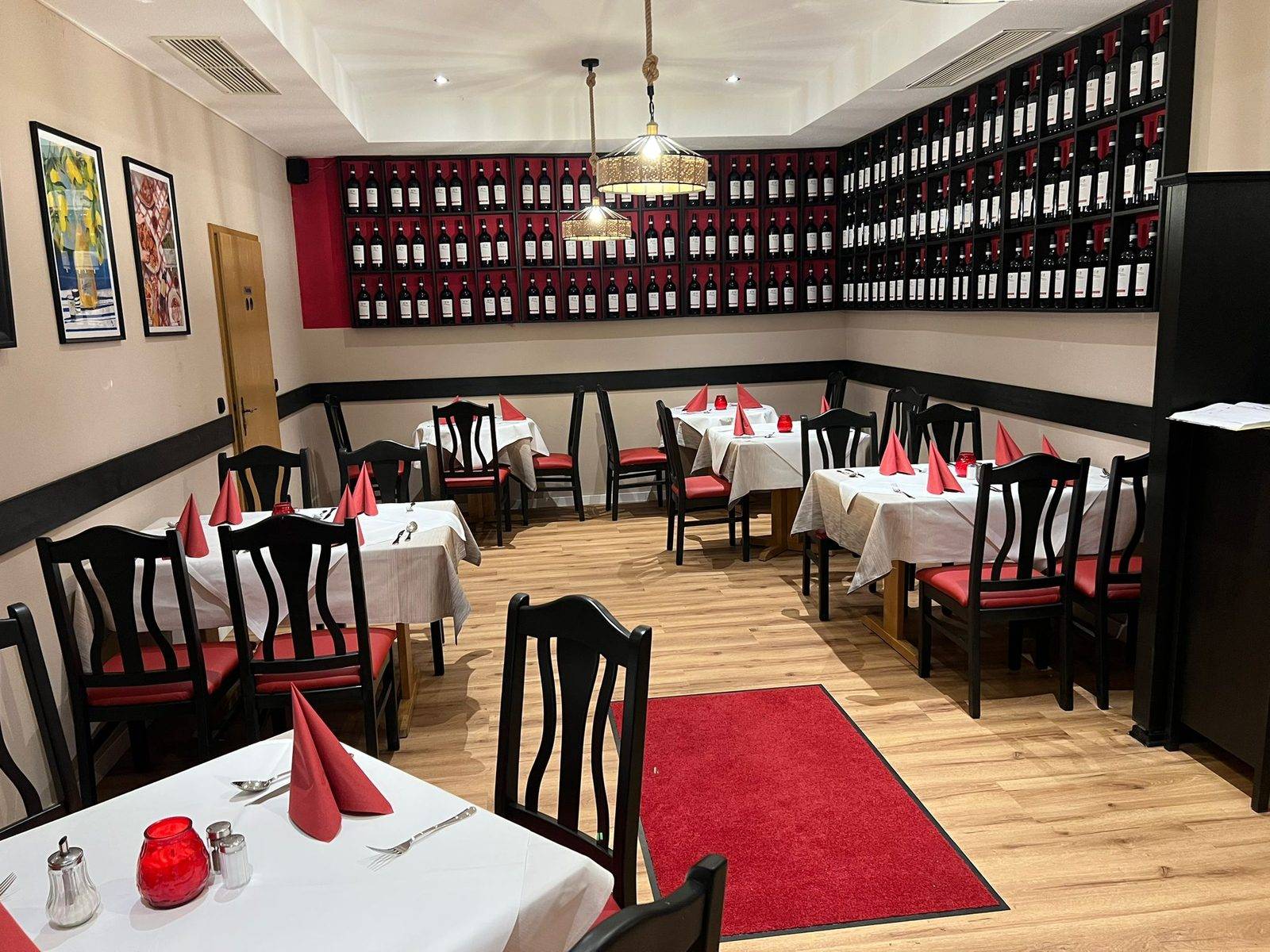 Dining room with wine wall, white tablecloths and red napkins